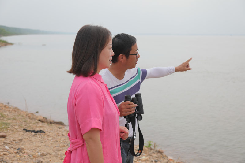 自愿者徐建利（右），，向王琼解说江豚拍摄点位和寓目角度。h49a1727.jpg